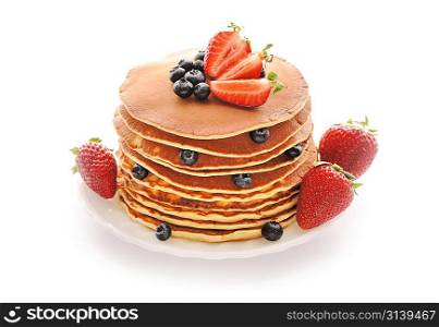 Delicious freshly prepared pancakes with strawberry and blueberries isolated on white