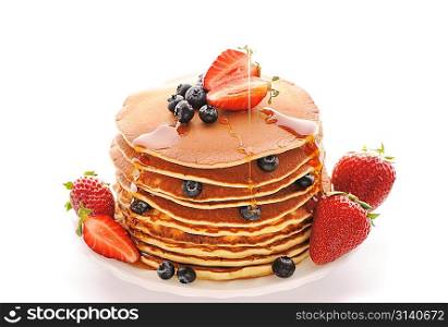 Delicious freshly prepared pancakes with strawberry and blueberries isolated on white