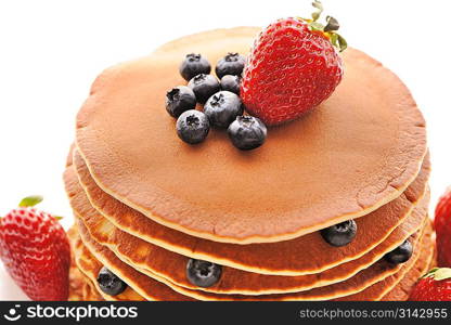 Delicious freshly prepared pancakes with strawberry and blueberries isolated on white