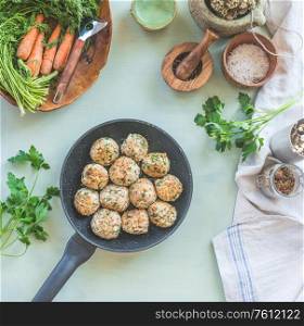 Delicious fried buckwheat balls in frying pan on kitchen table background with seasonings and herbs. View from above. Concept of healthy homemade vegan food. Home cuisine