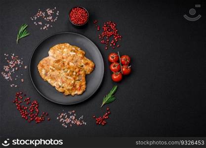 Delicious fried chicken breast in batter with mustard, salt, spices and cheese on a dark concrete background