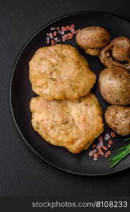 Delicious fried chopped fillet pancakes with spices, salt and herbs on a dark concrete background