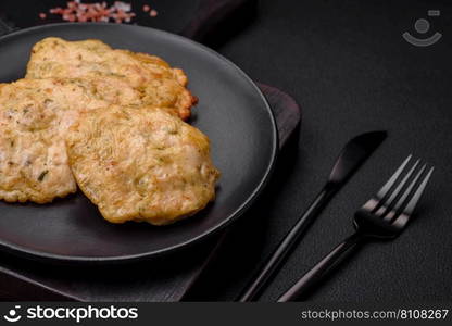 Delicious fried chopped fillet pancakes with spices, salt and herbs on a dark concrete background