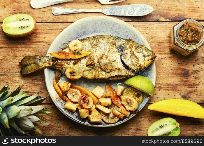 Delicious fried fish dorada with fruits and spices.. Baked grilled fish in fruit.