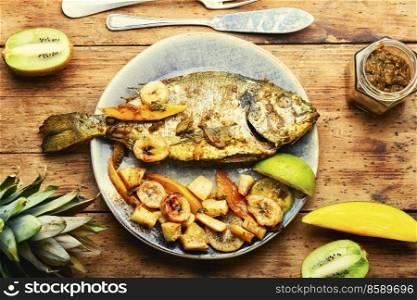 Delicious fried fish dorada with fruits and spices.. Baked grilled fish in fruit.