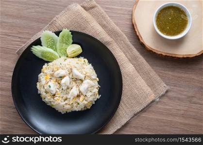 Delicious Fried rice with crab meat, egg, garlic, cucumber, lemon. Thai food called Khao pad poo. top view on wooden background. flat lay.