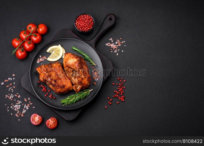 Delicious fried sea bass fish in the form of slices with spices and herbs on a ceramic plate on a dark concrete background