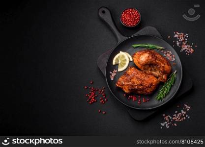 Delicious fried sea bass fish in the form of slices with spices and herbs on a ceramic plate on a dark concrete background