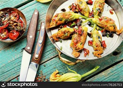 Delicious fried zucchini flowers stuffed with sun-dried tomatoes.Summer food.. Fried zucchini flowers with filling.