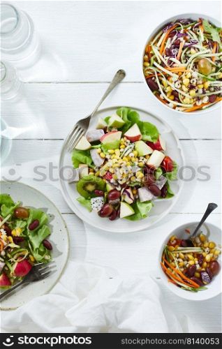 Delicious fruit salad and different fruits on the white table, healthy food concept 