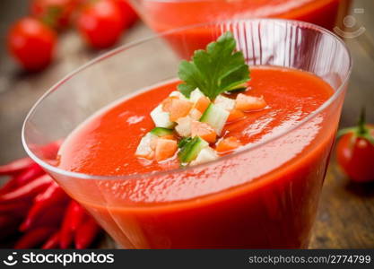 Delicious gazpacho on wooden table with fresh vegetables