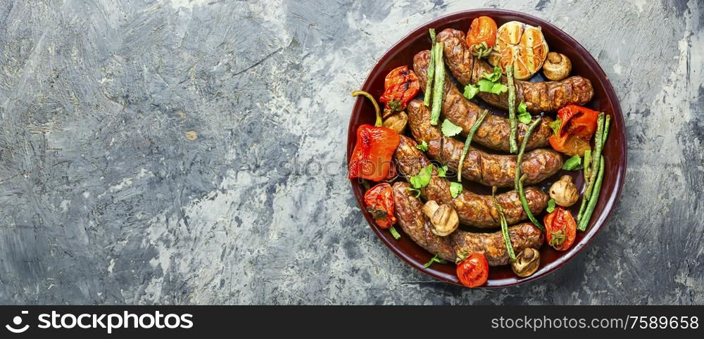 Delicious german sausages with grilled mushrooms and tomatoes.BBQ with sausage. Sausages fried with vegetable