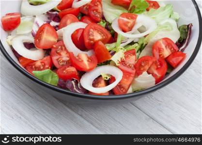Delicious green salad with tomatoes and onion rings