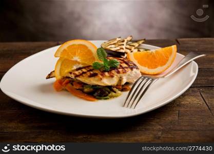 delicious grilled chicken breast with orange on ratatouille bed