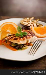 delicious grilled chicken breast with orange on ratatouille bed