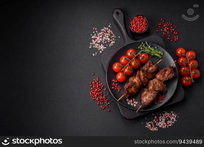 Delicious grilled chicken, turkey or pork skewers with salt, spices and herbs on a fire on a dark concrete background