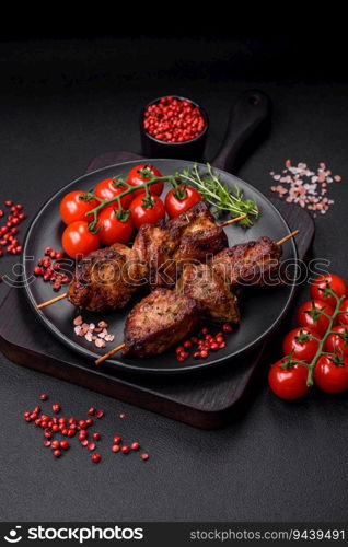 Delicious grilled chicken, turkey or pork skewers with salt, spices and herbs on a fire on a dark concrete background