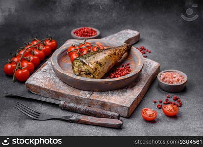 Delicious grilled mackerel with salt, spices and herbs on a textured concrete background