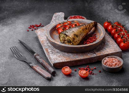 Delicious grilled mackerel with salt, spices and herbs on a textured concrete background