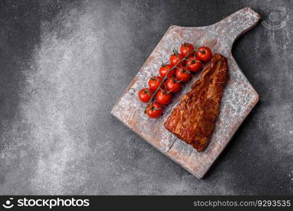 Delicious grilled or smoked pork ribs with salt, spices and herbs on textured concrete background