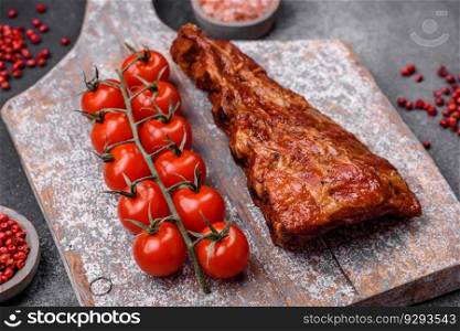 Delicious grilled or smoked pork ribs with salt, spices and herbs on textured concrete background