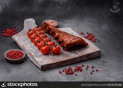 Delicious grilled or smoked pork ribs with salt, spices and herbs on textured concrete background