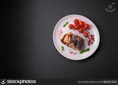 Delicious grilled salmon fillet with salt, spices, herbs and sauce on a dark concrete background
