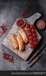 Delicious grilled sausages from chicken or pork meat with salt, spices and herbs on a textured concrete background