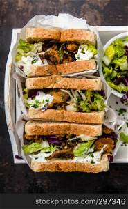 delicious gyros sandwich in paper bag with salad and tzatziki, top view,