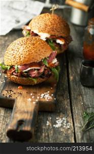 Delicious hamburger with beef with sauce and goat cheese on a wooden background