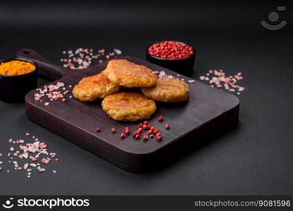 Delicious hearty vegetarian or vegan dish in the form of cutlets or patties consisting of potatoes, carrots, onions and beans on a dark concrete background