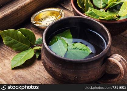 .Delicious herbal tea with bay leaf on wooden background. Cup of herbal tea