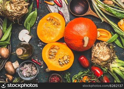 Delicious hokkaido pumpkin with mushrooms and vegetables ingredients for tasty cooking on dark rustic background, top view