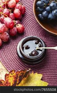 Delicious homemade autumn grape jam.Autumn dessert.Autumn still life. Jar of grape jam.
