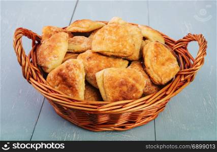 delicious homemade biscuits in wicker basket on vintage wooden table