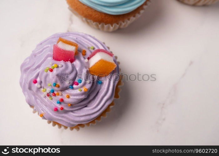 Delicious homemade cupcakes with Colorful cream and topping with candy and Chocolate Cookies. Homemade autumn holiday dessert