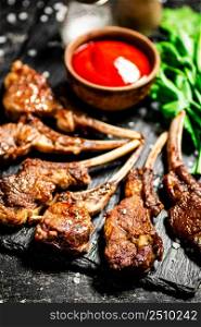 Delicious homemade grilled lamb rack. On a black background. High quality photo. Delicious homemade grilled lamb rack.