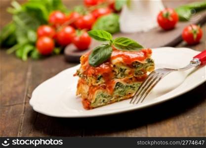 delicious homemade lasagne with ricotta cheese and spinach on wooden table