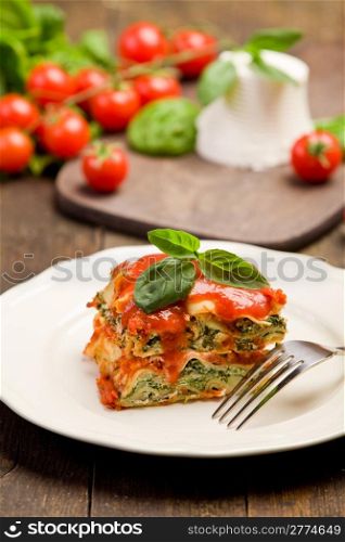 delicious homemade lasagne with ricotta cheese and spinach on wooden table