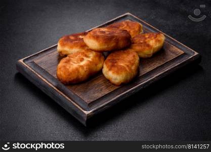 Delicious homemade pies with potatoes on a dark concrete background. Home cooked pastries. Delicious homemade pies with potatoes on a dark concrete background