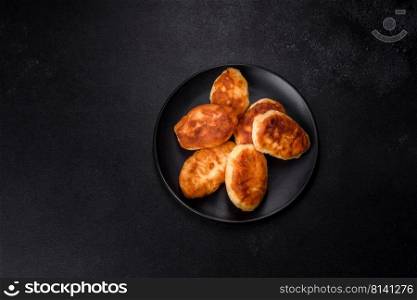 Delicious homemade pies with potatoes on a dark concrete background. Home cooked pastries. Delicious homemade pies with potatoes on a dark concrete background