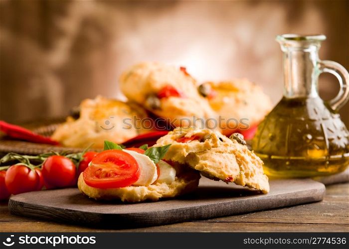 delicious homemade pizza rolls stuffed with tomatoe and mozzarella on wooden table