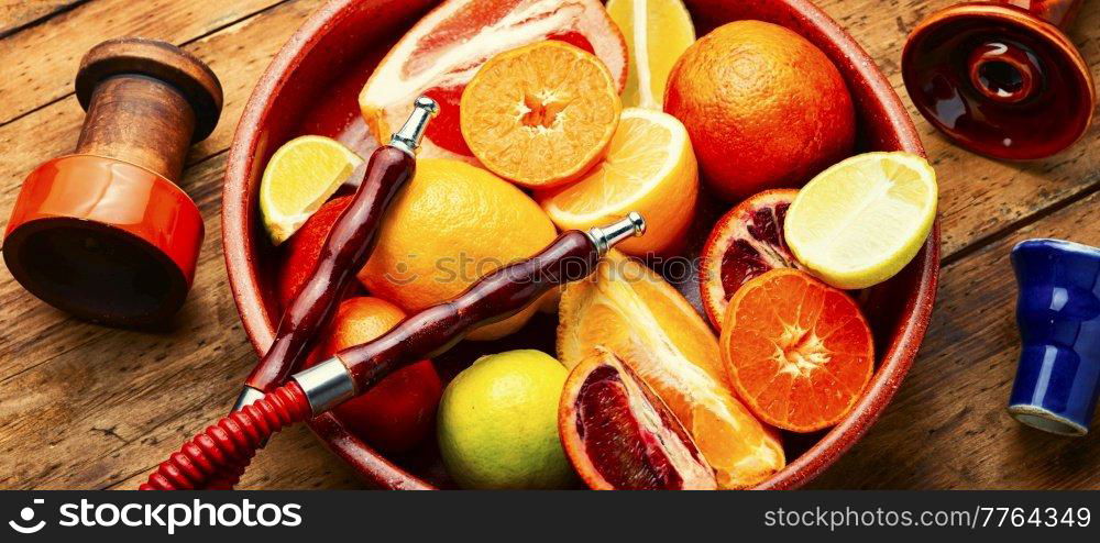 Delicious hookah with orange, lime, lemon and grapefruit. Relaxation citrus hookah tobacco.. Smoking hookah with citrus fruits.