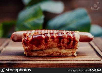 Delicious hot dog with sausages on a wooden board.