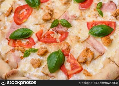 Delicious hot pizza with chicken, tomatoes, cheese and bacon, with salt and spices and on a dark concrete background