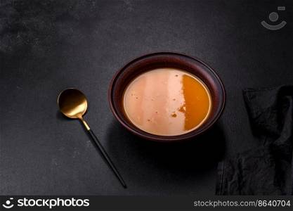 Delicious hot pumpkin and carrot soup puree with spices and herbs. Vegetarian cuisine. Delicious hot pumpkin and carrot soup puree with spices and herbs