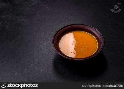 Delicious hot pumpkin and carrot soup puree with spices and herbs. Vegetarian cuisine. Delicious hot pumpkin and carrot soup puree with spices and herbs