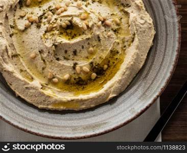 Delicious hummus with pine nuts and olive oil. Top view. Close-up.