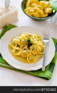 delicious italian fresh tortellini with butter and sage on green wooden table