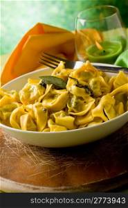 delicious italian fresh tortellini with butter and sage with green background